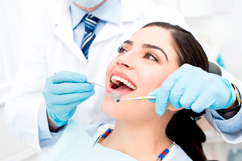 Immagine di donna dal dentista durante un trattamento di igiene orale professionale